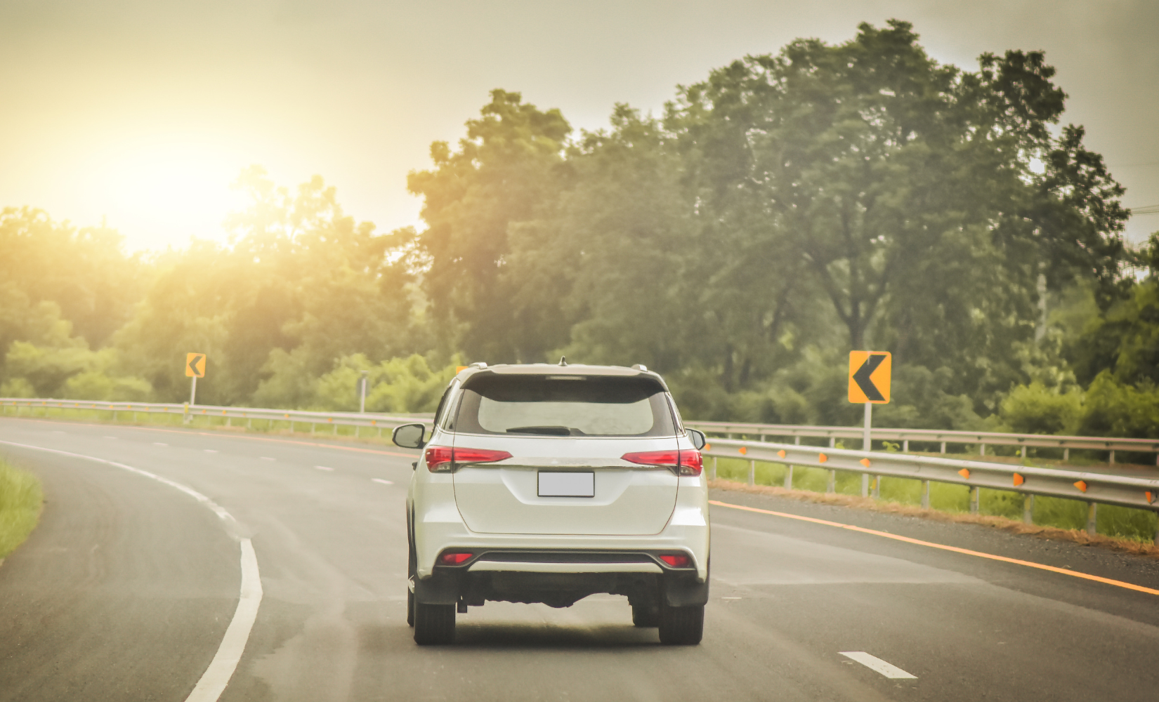 A car driving on a road viewed from the back.