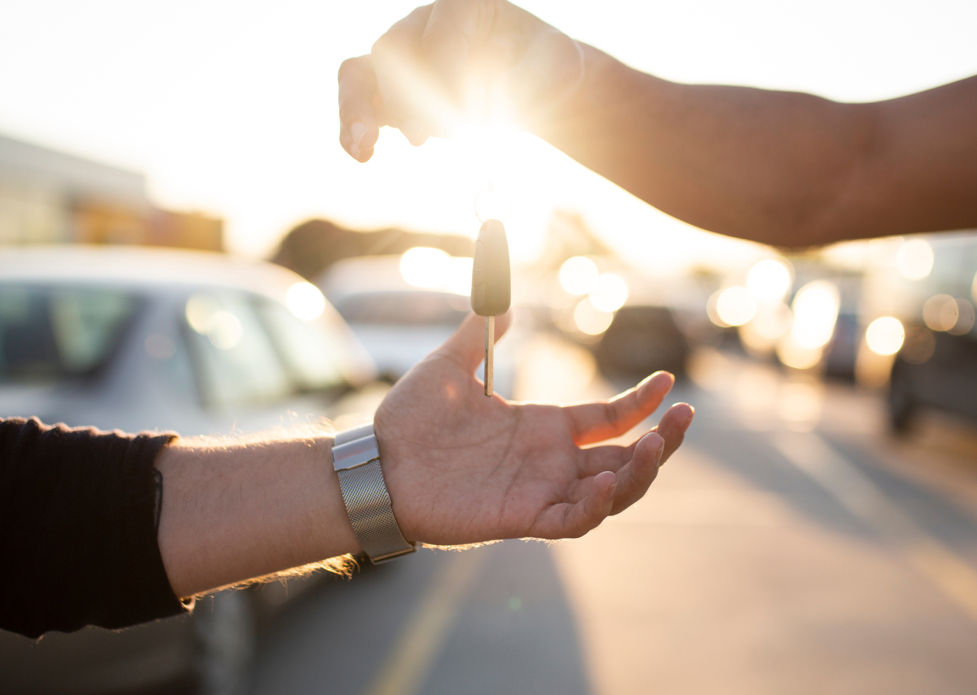 Two people exchanging a car key.