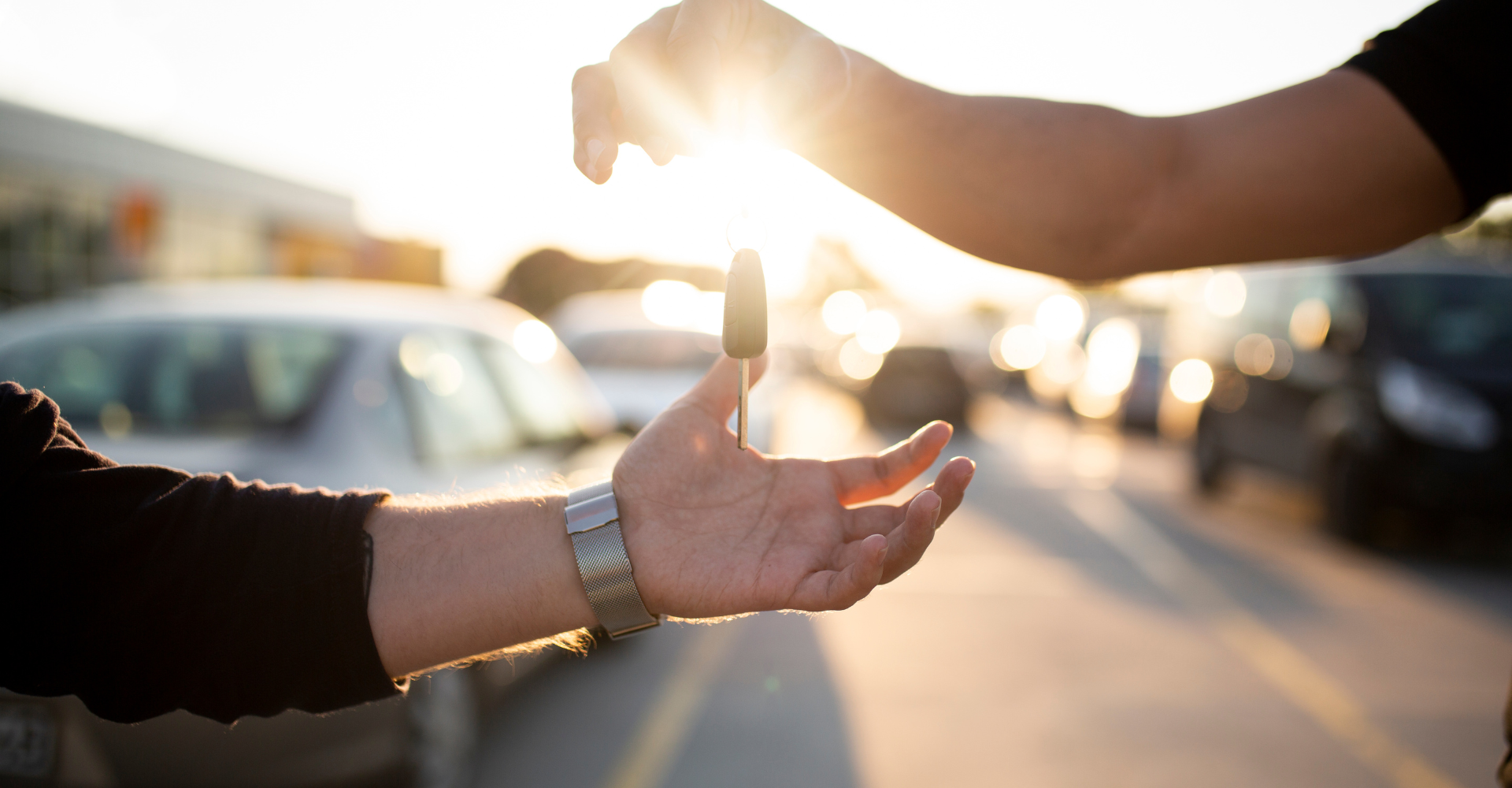 Two people exchanging a car key.