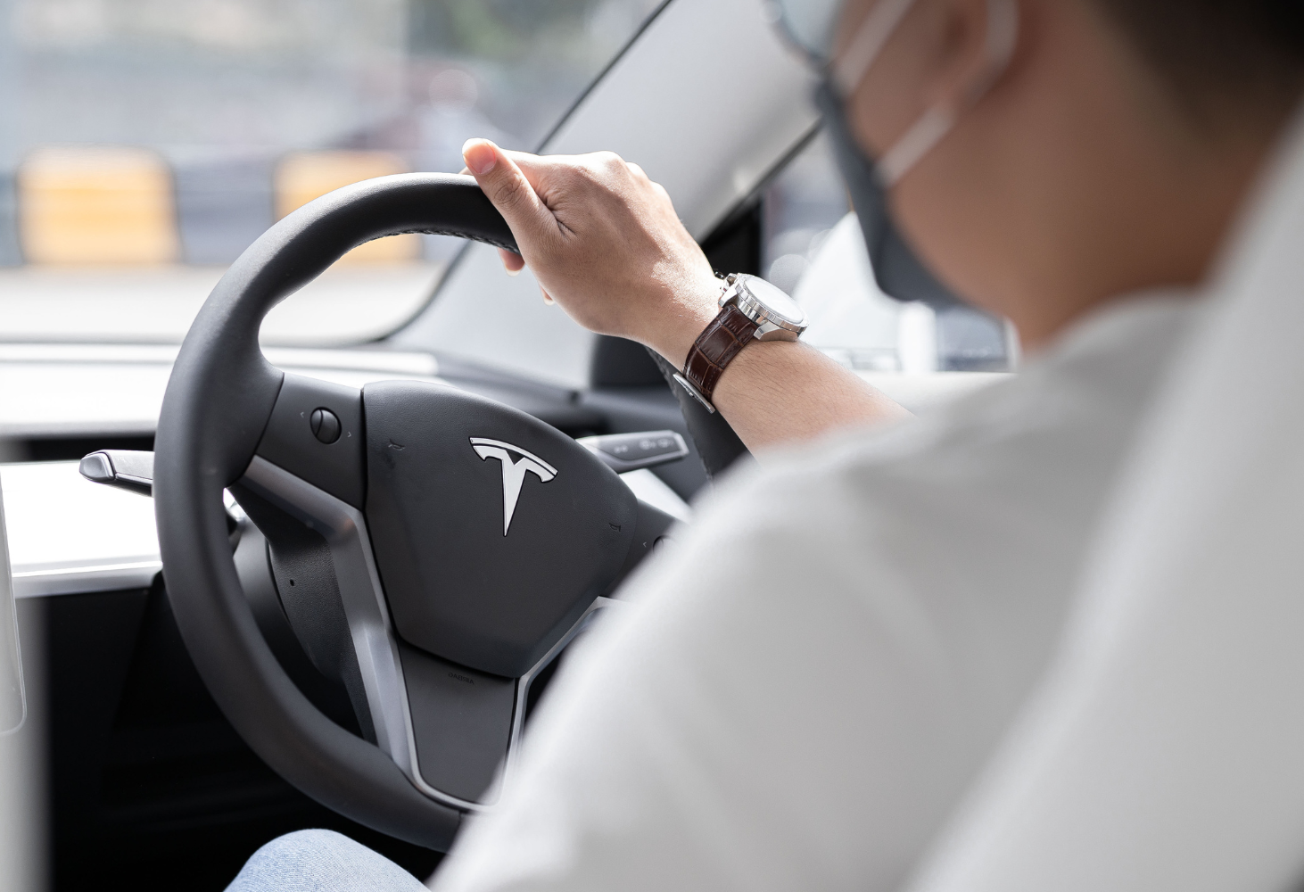 Back view of a man driving an EV.