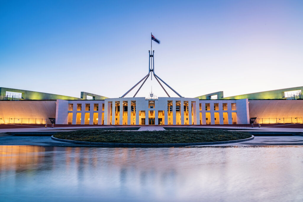 The Australian Parliament House, illuminated at dusk.